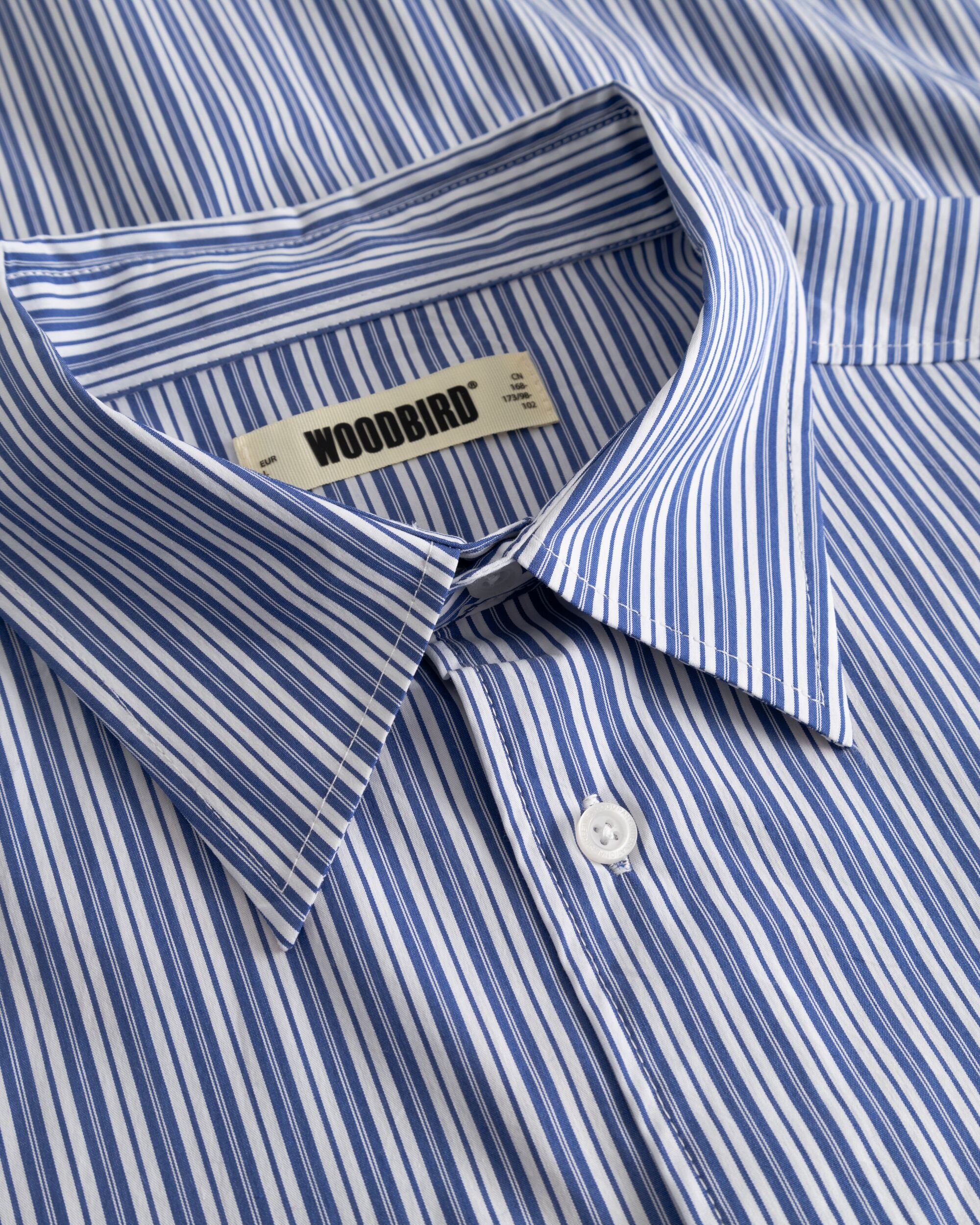 Woodbird WBBrooks Lion Shirt lichtblauw, close-up van de kraag en het Woodbird merklabel aan de binnenzijde.